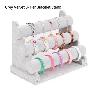Gray velvet 3-tier jewelry display stand for bracelets, bangles, and watches on white background