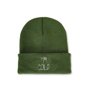 Detail shot of I'M COLD white embroidery on a dark green knitted beanie hat