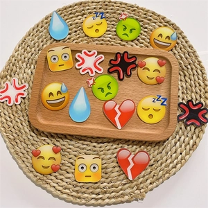 DIY colorful acrylic emoji charms with varied expressions on a rustic tray display