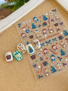 Close-up of 3D embossed Christmas nail stickers featuring bears and holiday trees
