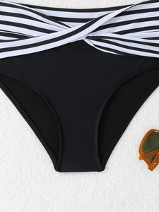 Dettaglio slip bikini nero a vita alta con elegante dettaglio a incrocio a righe