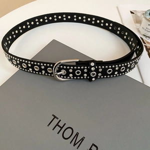 Close-up of punk leather belt with silver eyelets and sparkling crystal studs
