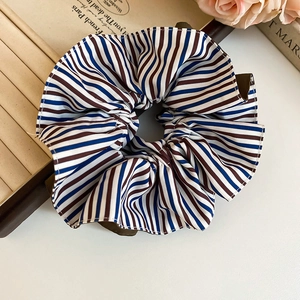 Vue détaillée d'un chouchou en tissu rayé sur un livre vintage avec des roses