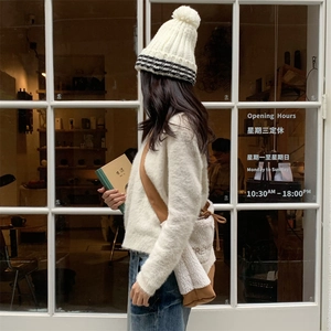 Détail du sac bandoulière d'hiver avec polaire blanche et design en patchwork marron