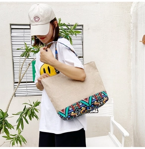 Close-up of beige tote bag with colorful geometric patterns on the base and strap