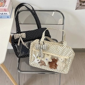 Close-up of canvas ita bag with clear window, polka dot pattern and ribbon detail