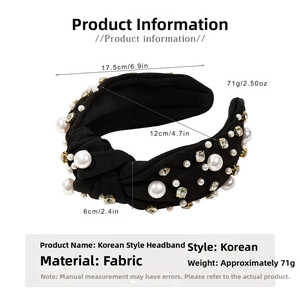 Detail of wide black fabric headband with oversized pearls and sparkling rhinestones