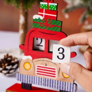 Detail of hand changing dates on a red wooden Christmas truck advent calendar