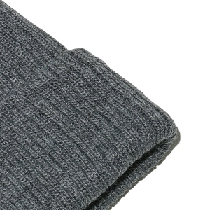 Detailed close-up of the thick ribbed knit texture on a grey striped wool beanie hat