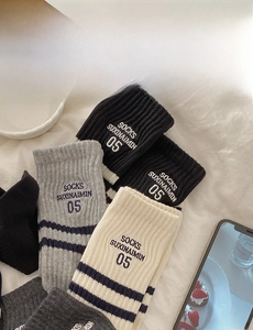 Detail view of cotton athletic socks with stripes and embroidered logo on ribbed fabric