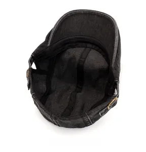 Detail view of washed denim newsboy cap featuring cotton sweatband and adjustable buckle