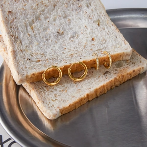 Classic 18K gold plated stainless steel wave hoop earrings set on bread display