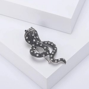 Detailed view of cobra brooch with vintage black alloy and sparkling white rhinestones