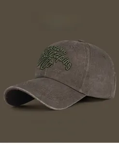 Detail of vintage washed cotton baseball cap featuring green 3D embroidery and worn finish