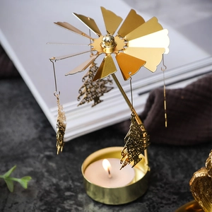 Golden rotating candle holder with Christmas tree pendants and warm tea light glow
