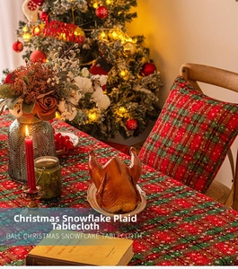 Close-up of red and green plaid Christmas tablecloth with white snowflake patterns