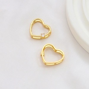 Macro detail of gold-plated hollow heart charms with tiny sparkling cubic zirconia