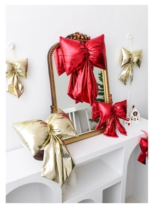 Close-up of shiny red and gold Christmas bows decorating a mirror and cabinet in a cozy room