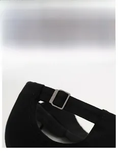 Detail of adjustable metal buckle on black twill cotton baseball cap for custom fit