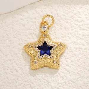 Detailed close-up of a gold-plated star pendant with a blue gem and sparkling zircon stones