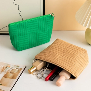 Detailed view of checkered velvet makeup bags in vibrant green and khaki with gold zippers