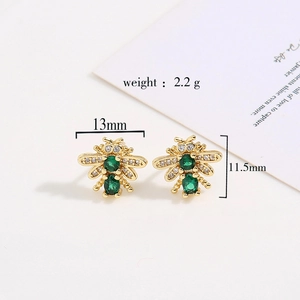 Golden bee stud earrings with green zircon and sparkling stones on white background