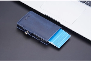 Close-up of blue textured leather RFID card holder with automatic slide-out button mechanism