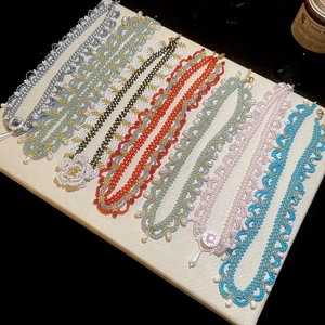 Detailed view of handmade beaded necklaces with floral patterns and pearl accents