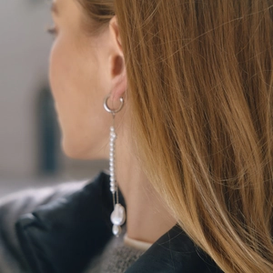 Elegant silver tassel earrings with delicate white pearls and baroque drop on model