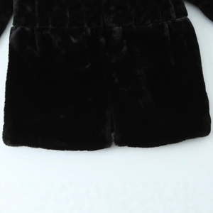 Gros plan de l'ourlet d'une veste en fausse fourrure noire montrant une texture douce