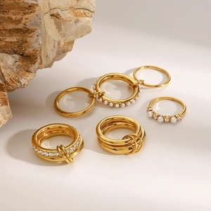 Detail of gold stacked rings with pearls and micro-pave diamonds on natural stone