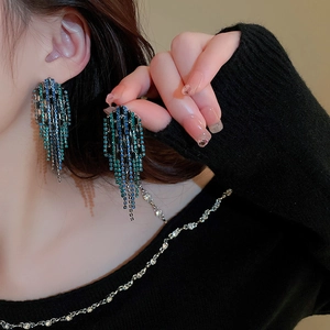 Close-up of blue rhinestone fringe earrings on a model showing the elegant waterfall drop