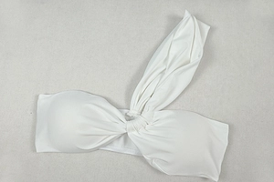 Detail of white one-shoulder bikini top with pleated fabric and decorative shoulder knot