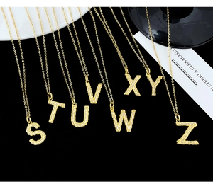 Detailed macro view of S-Z alphabet pendants in gold plating with white zircons