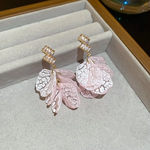 Detail of pink resin petal drop earrings with gold geometric metal and zircon inlay