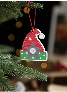 Close-up of a wooden Christmas hat ornament with star patterns on a festive tree