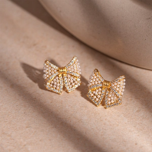 Elegant bow knot earrings with imitation pearls and sparkling zircons in gold setting