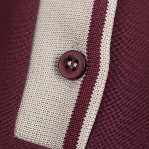 Détail du col d'une robe polo en maille bordeaux avec bouton classique assorti