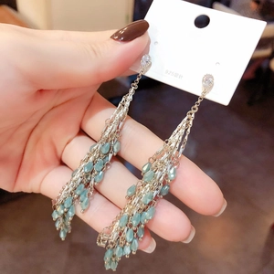 Detail view of long silver tassels with light green waterdrop glass beads on 925 silver pins