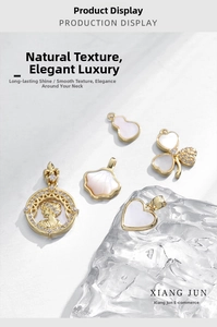 Detailed view of 18k gold plated charms with white shell inlays and zircons