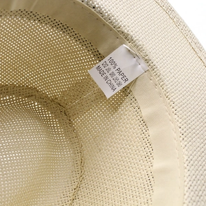 Macro shot of straw hat interior showing 100% paper material label and sweatband