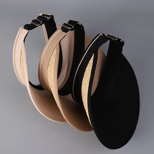 Détail de visières en raphia réglables en noir et beige avec boucles métalliques