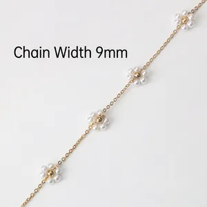 Detailed view of 9mm golden chain with white pearl flower accents and beaded centers