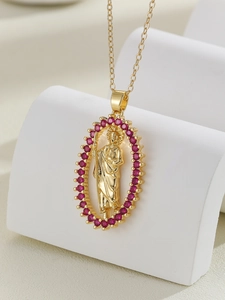 Macro detail of golden Virgin Mary pendant with red cubic zirconia and metal relief