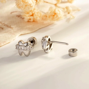 Chic silver tooth-shaped cartilage earrings with sparkling zircons and screw backings