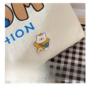 Detail der Canvas-Tasche mit süßer Teddybär-Stickerei und stilvollem Buchstabendruck