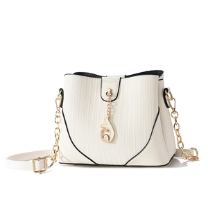 White minimalist bucket bag with gold chain and textured finish for summer 2025 style