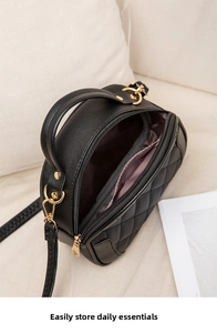 Internal view of a black quilted handbag showing the spacious lilac-lined compartment