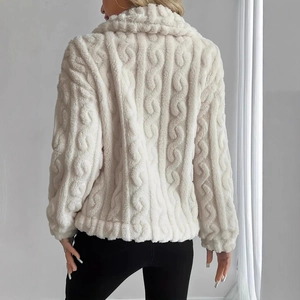 Close-up of cream white plush jacket featuring intricate cable knit patterns and warm texture