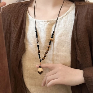 Retro Chinese style long necklace with wood beads and pine nut pendant on a model